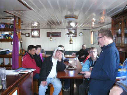 Foto: Unser erster Amateurfunkerkurs auf hoher See. Falk erzählt und hält sein Handfunkgerät in der Hand. 