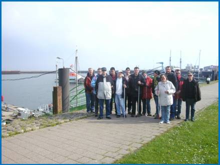 Gruppenfoto auf Borkum. Im Hintergrund ist der Hafen und der Seenotkreuzer der Küstenwache zu sehen.