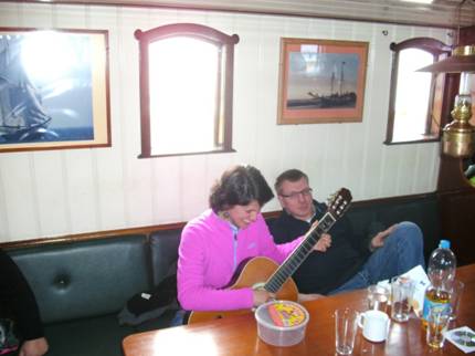 Foto: Anne spielt für uns etwas Gitarre auf hoher See. Gemeinsam wird ein wenig gesungen.